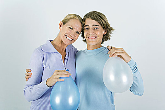 母亲,青少年,儿子,抱臂,相互,肩部,拿着,气球,看镜头,微笑