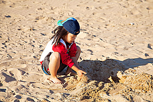 一个可爱的女孩在海边的沙滩上玩耍