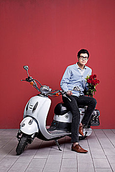 骑摩托车送玫瑰的亚洲男孩