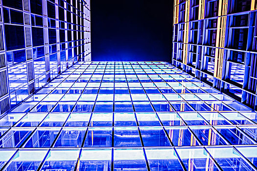 摩天高楼的窗户辉光在夜间现代化的办公大楼,晚上
