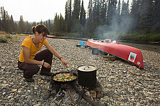 年轻,女人,烹调,油炸,鸡肉,搅动,露营,独木舟,桌子,后面,砾石,河,育空地区,加拿大