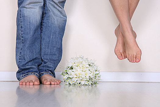 一对男女的脚旁放着一束鲜花
