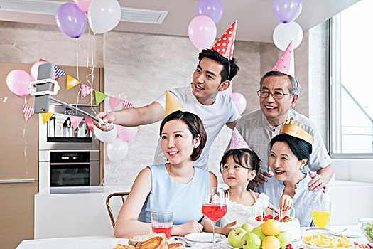 快乐的一家人在厨房聚会庆祝,拿着手机自拍