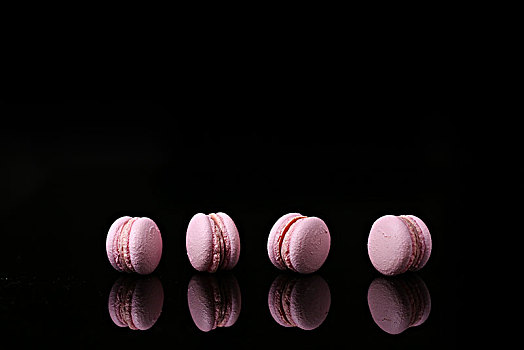 黑色倒影板上的粉色草莓味马卡龙
