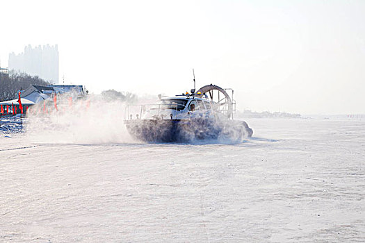 雪地上飞驰的气垫船激起白色的雪花