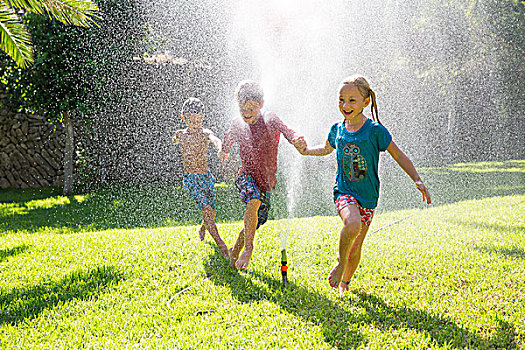 三个孩子,花园,跑,喷灌机