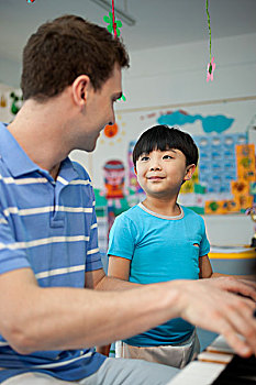 外教和小男孩一起弹钢琴