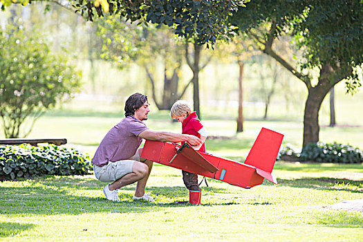 父亲,蹲,准备,飞机模型,儿子,公园
