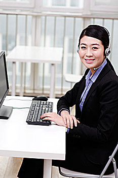 商务女士头戴耳机使用电脑