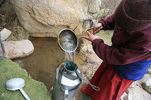 西藏拉萨米穷日寺的尼姑们在泉水边打水