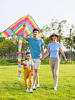 快乐的三口之家在公园放风筝