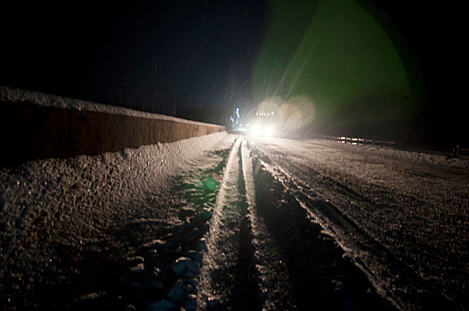 灯光照耀着有积雪的路面