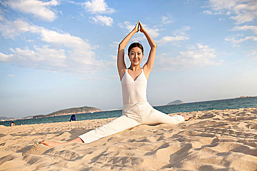 在沙滩上练瑜伽的女士