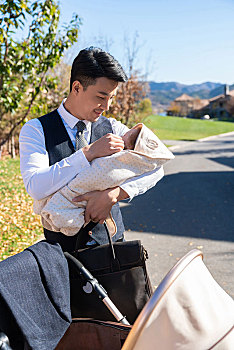 年轻商务男士抱着婴儿