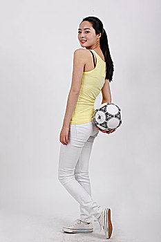 一个拿着着足球的青年女士