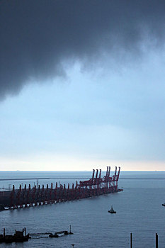 山东省日照市,海面上空阴云密布,万吨巨轮静泊锚地处变不惊