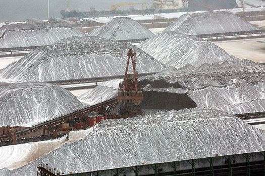 山东省日照市,狂风暴雪席卷港城,港口生产受阻,红色矿石堆场变身,雪山