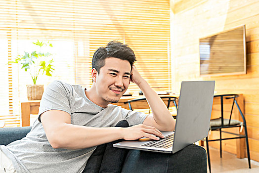年轻男子在沙发上使用电脑
