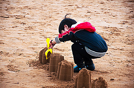 沙滩玩沙的男孩