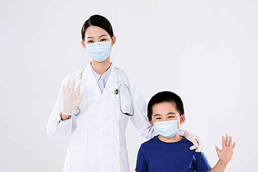 一位女医生和小男孩做出招手的手势