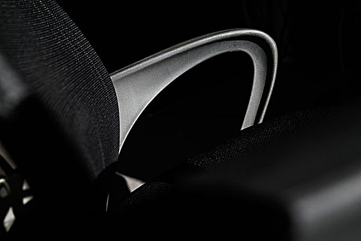 黑色塑料办公靠椅局部,弧形的扶手