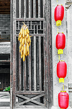 挂红灯笼的徽派民居木门上的黄色玉米