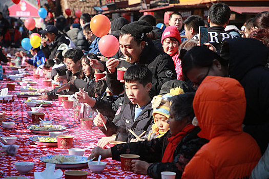 小镇摆下百米长桌宴,市民游客新年吃饺子交好运