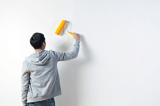 青年男子粉刷墙壁