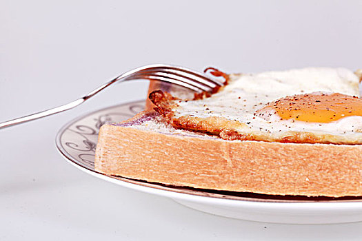 特写用叉子吃煎鸡蛋配面包