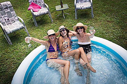 三个,成熟女性,坐,涉水,游泳池,喝,葡萄酒,俯视图