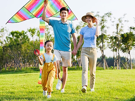 快乐的三口之家在公园放风筝