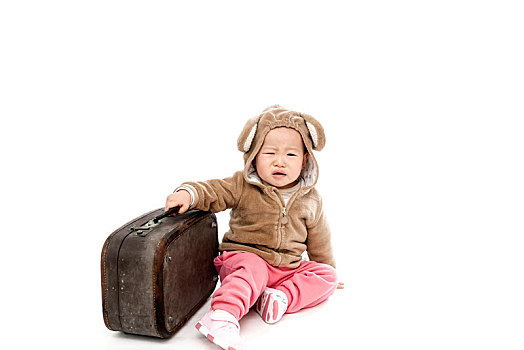 儿童提着行李箱去旅行