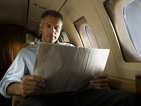 仰视,商务人士,读,报纸,飞机