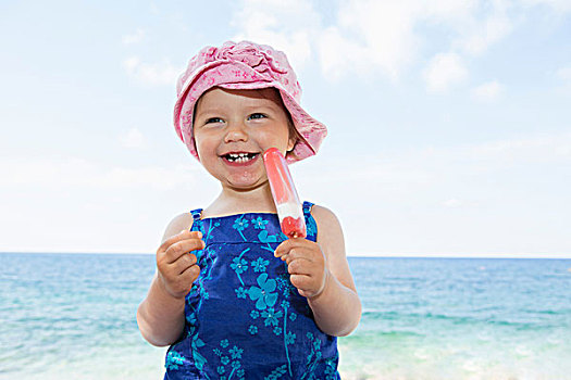 女性,幼儿,戴着,太阳帽,吃,冰棍,海滩