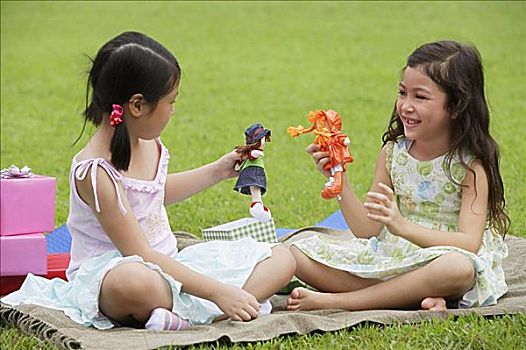 两个女孩,坐,野餐毯,玩,娃娃