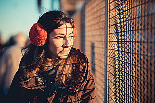 中年,女人,戴着,红色,耳罩,注视,日光,铁丝栅栏