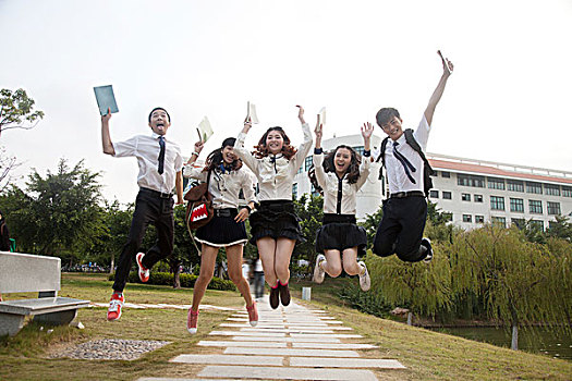 五个大学生在校园里跳跃