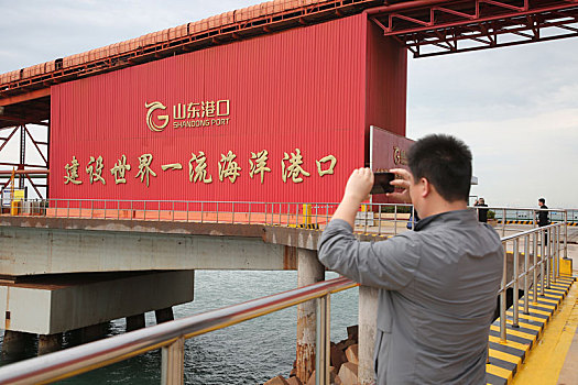 山东省青岛市,鸟瞰40万吨级矿石码头雄伟壮观,远洋巨轮靠泊港区装卸繁忙有序