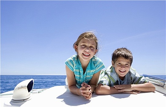 男孩,女孩,8-10岁,趴着,甲板,帆船,室外,海上,并排,微笑,正面,头像