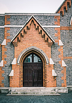 一个华丽的维多利亚砖牌楼和一所教堂的木门的细节