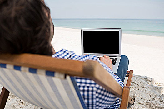 后视图,男人,使用笔记本,海滩,坐,折叠躺椅