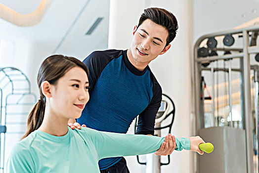 年輕女子在私教的指導下健身