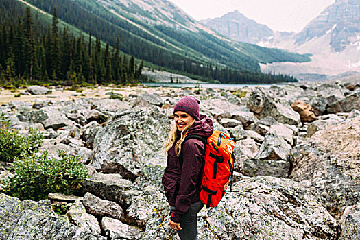 侧面视角,中年,女人,岩石,风景,背包,看镜头,微笑,冰碛湖,班芙国家公园,艾伯塔省,加拿大