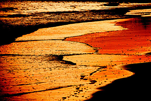 夕阳映照下的彩色沙滩