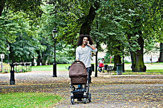 男青年,推,婴儿车,公园,交谈,手机