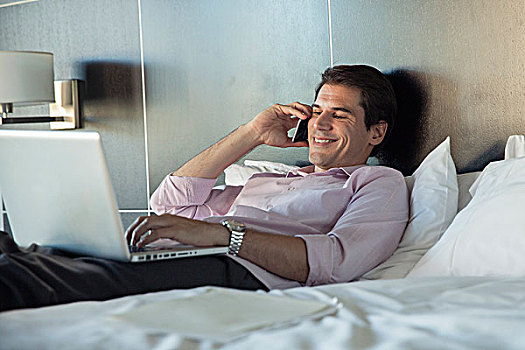 男人,卧,床上,手机,笔记本电脑