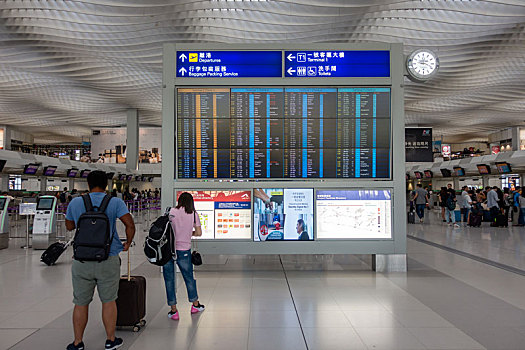 旅客们正在香港国际机场查看航班信息