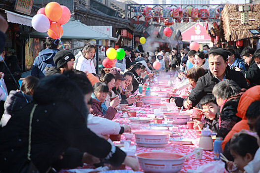 小镇摆下百米长桌宴,市民游客新年吃饺子交好运