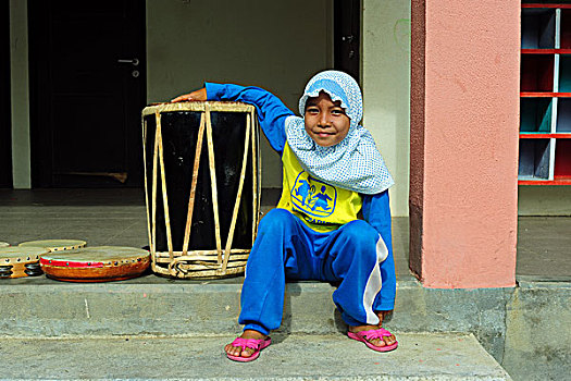 indonesia,sumatra,banda,aceh,young,veiled,girl,with,sos,outfit,playing,the,drums