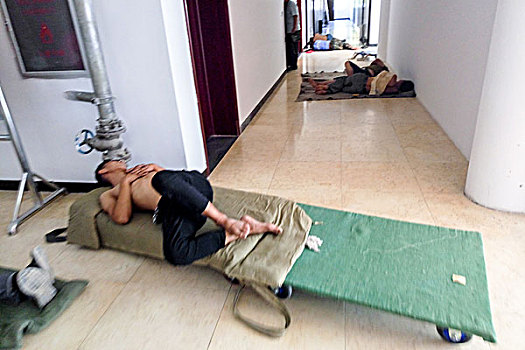 河南滑县,37度高温下搬家农民工在机关办公楼大厅走廊午睡工作人员轻轻走过不忍惊扰他们的梦